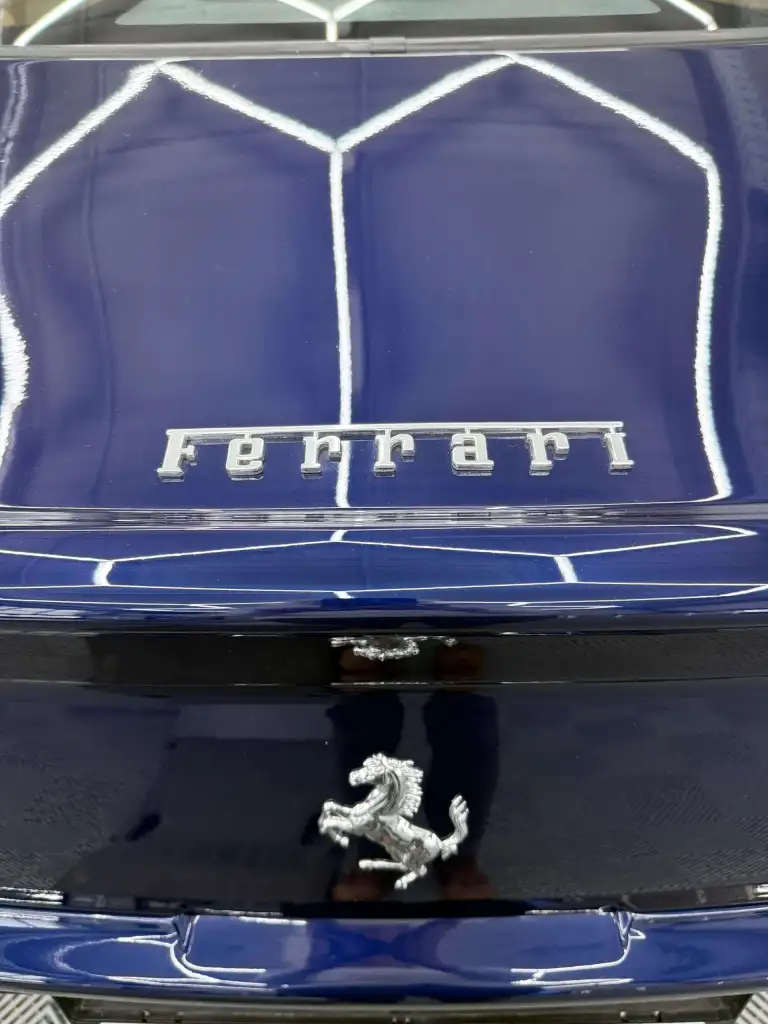 Ferrari Emblem auf blauem Auto